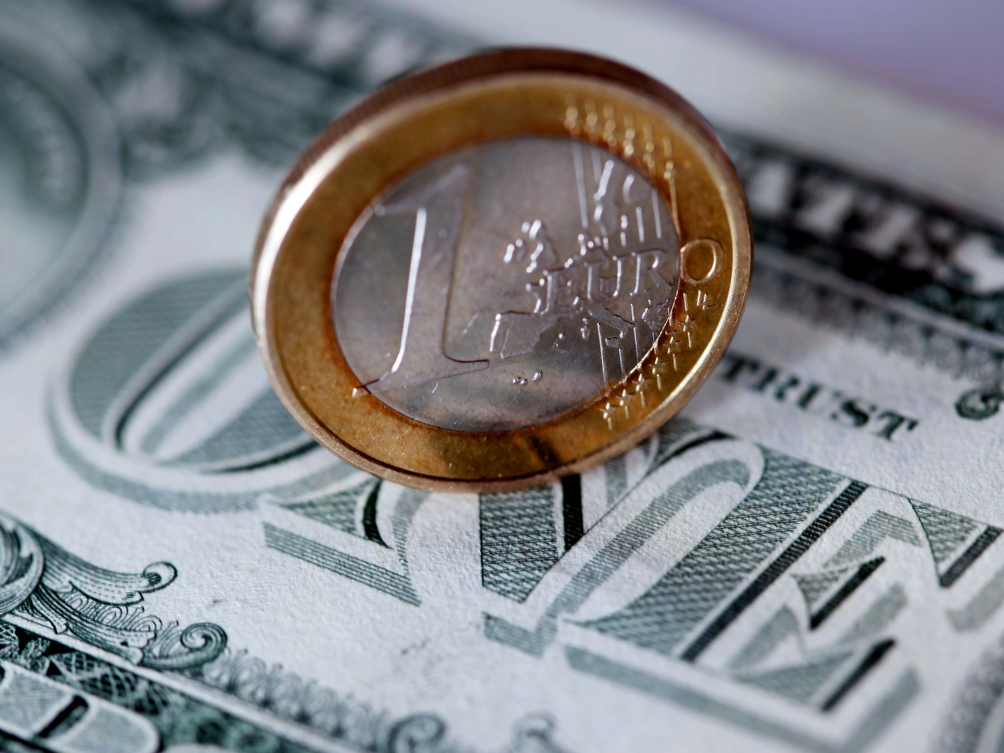 Eine Ein-Euro-Münze steht auf einem Ein-Dollar-Schein. Der Eurokurs ist erstmals seit fast 20 Jahren auf ein Dollar-Tauschverhältnis von eins zu eins gefallen.