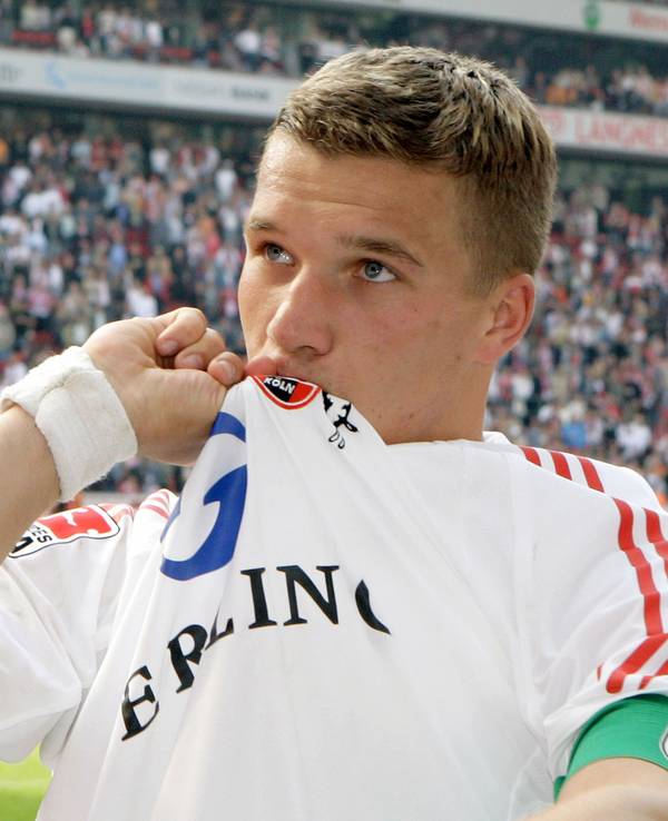 Der Kölner Nationalspieler Lukas Podolski verabschiedet sich von den Fans und küsst das Kölner Wappen auf seinem Trikot
