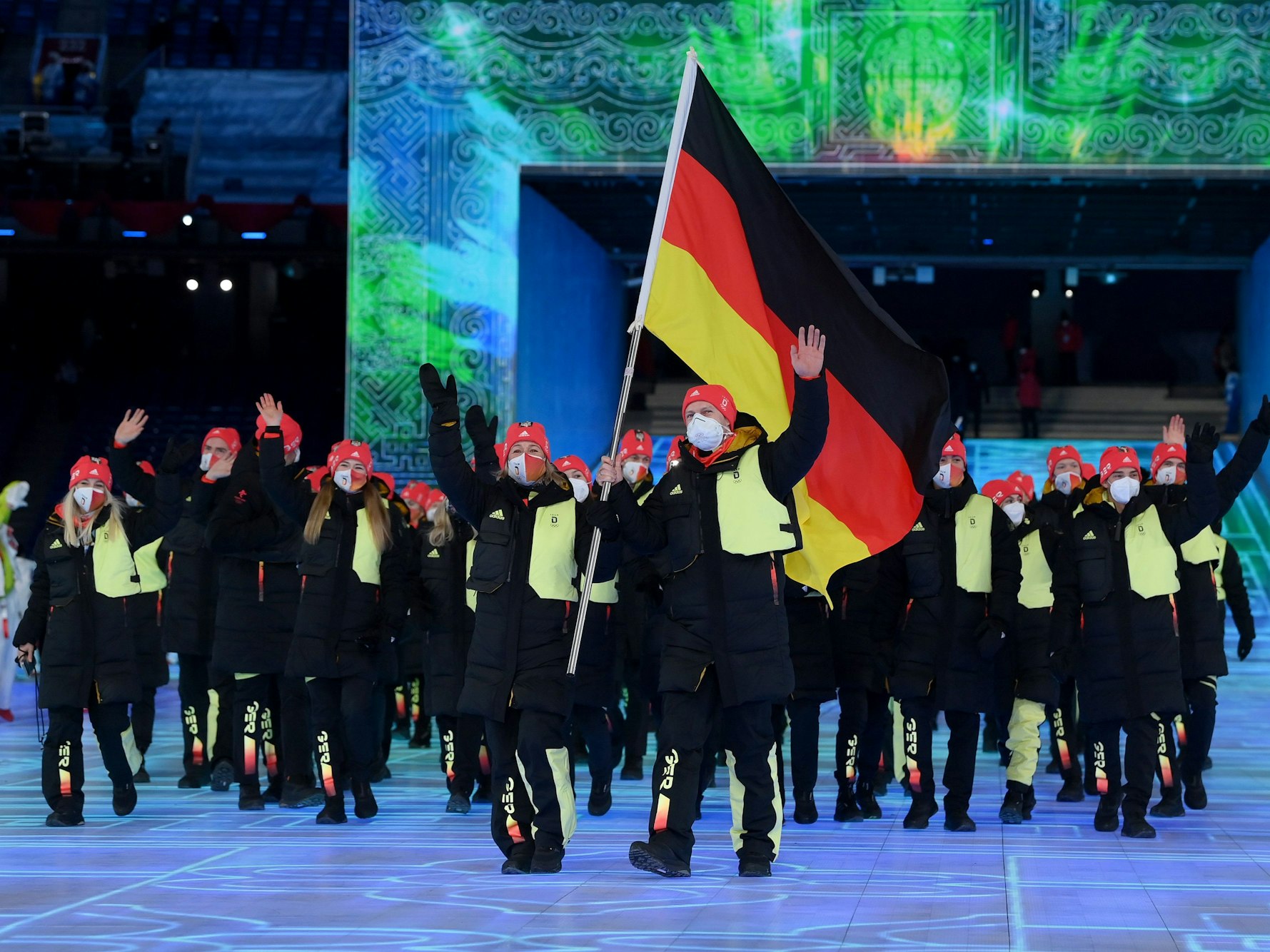 Francesco Friedrich und Claudia Pechstein tragen die deutsche Fahne ins Stadion in Peking