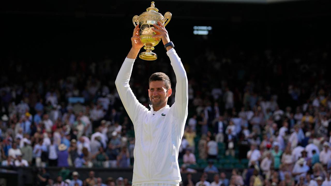 Novak Djokovic hält die Wimbledon-Trophäe über seinem Kopf.