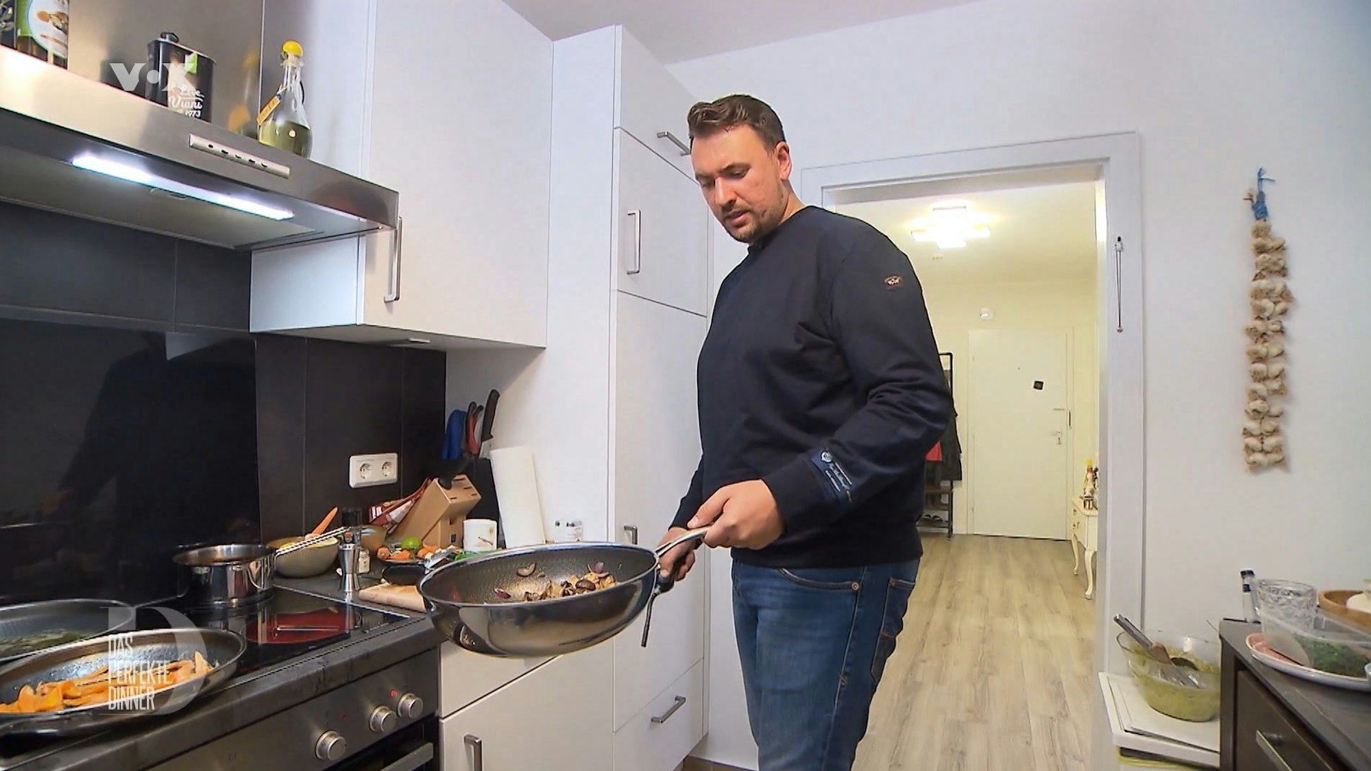 Gastgeber David steht am zweiten Tag von Das perfekte Dinner in Bremen in seiner Küche