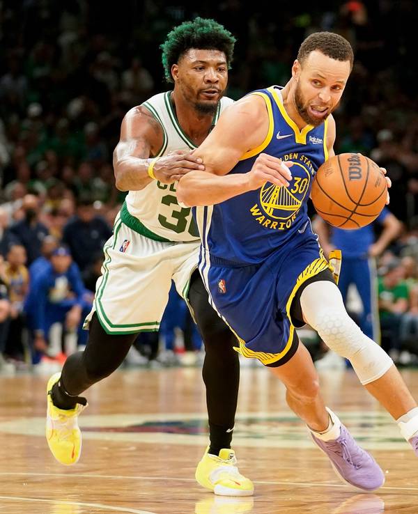 Stephen Curry (r) führt den Ball und wird von Marcus Smart (l) gestört.