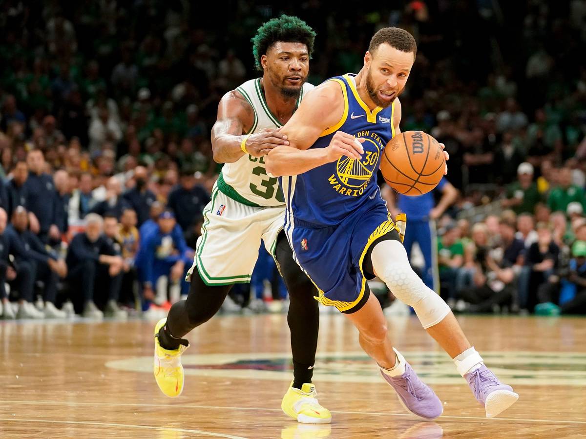 Stephen Curry (r) führt den Ball und wird von Marcus Smart (l) gestört.