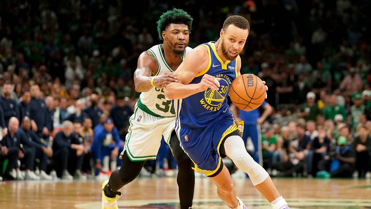 Stephen Curry (r) führt den Ball und wird von Marcus Smart (l) gestört.