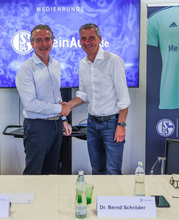 Schalkes Vorstandsvorsitzender Bernd Schröder und MeinAuto.de-Geschäftsführer Rudolf Rizzolli schütteln sich die Hand.