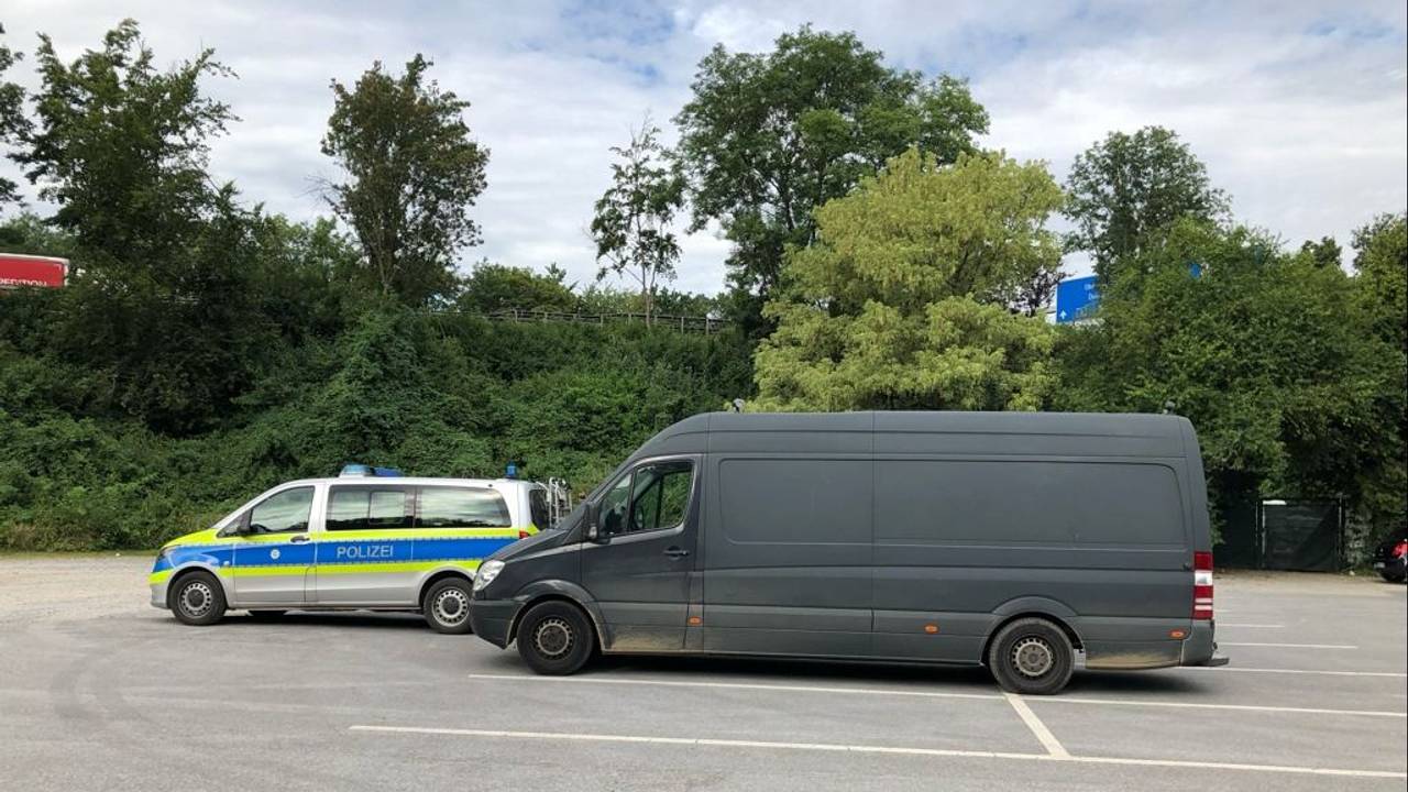 Ein überladener Mercedes Sprinter steht hinter einem Polizeiwagen auf einem Parkplatz.