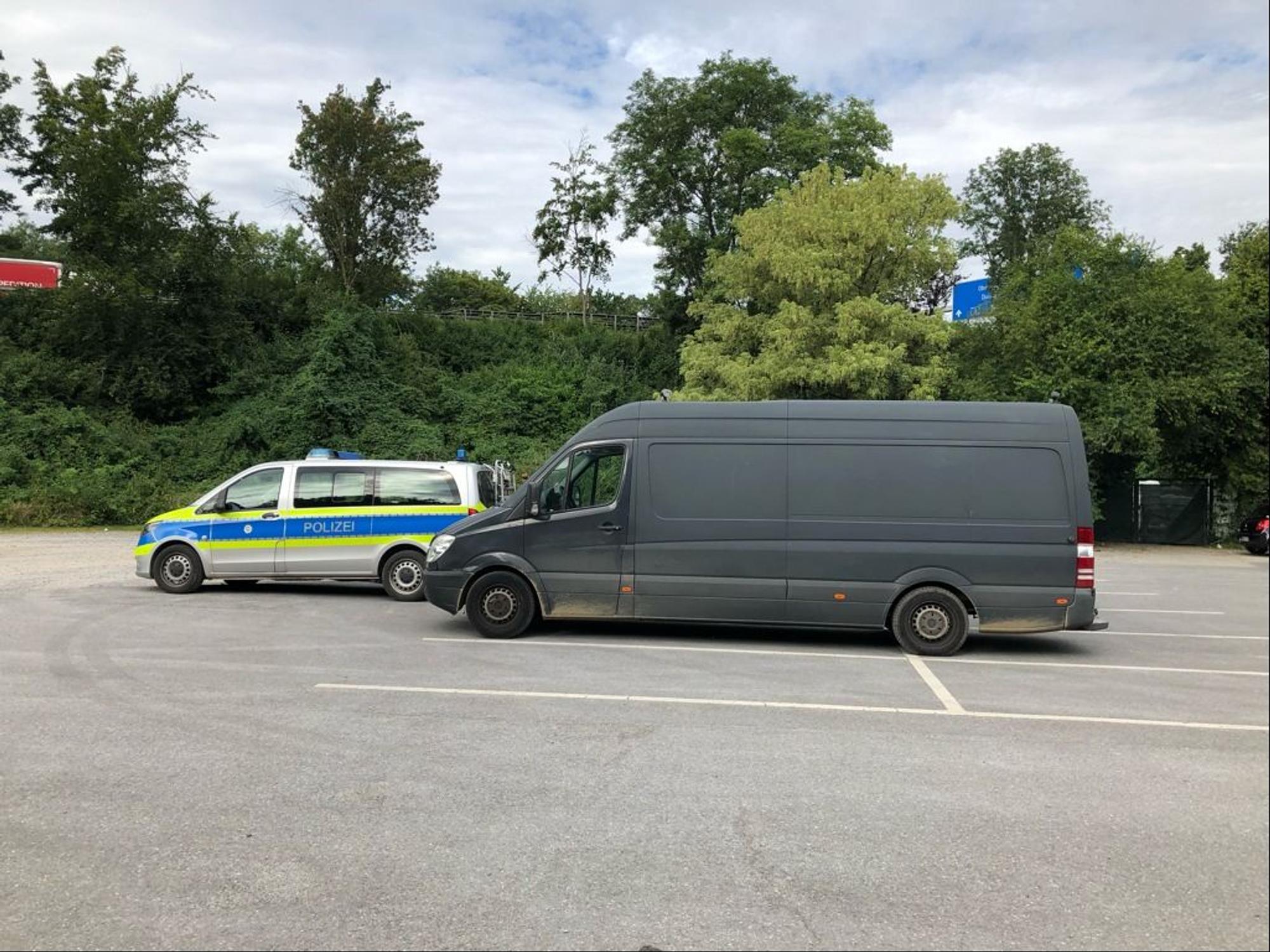 Ein überladener Mercedes Sprinter steht hinter einem Polizeiwagen auf einem Parkplatz.