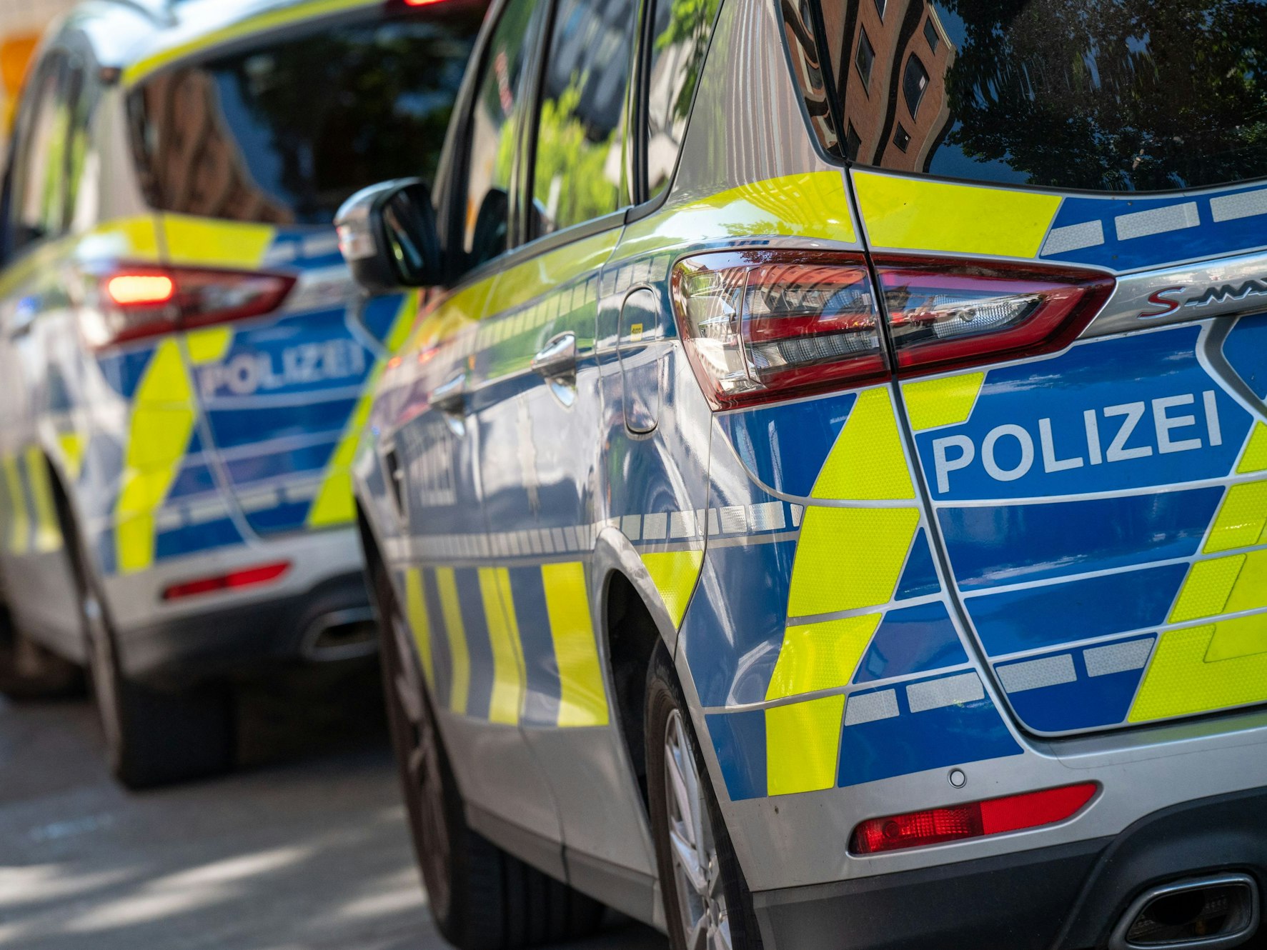 Polizei-Autos stehen in einer Straße hintereinander.