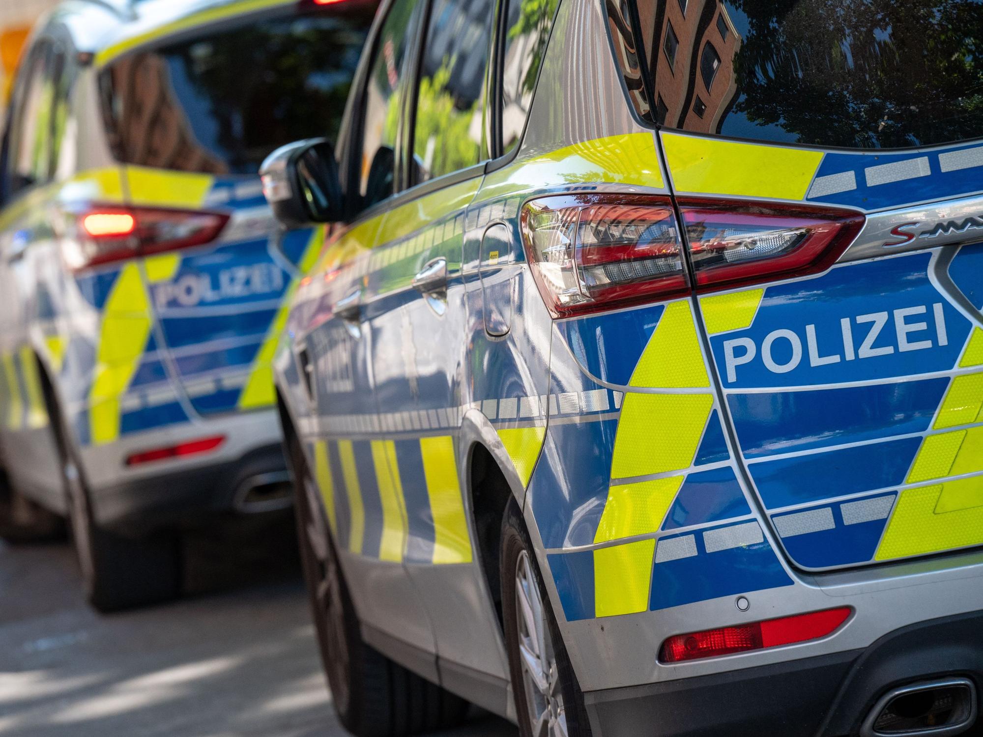 Polizei-Autos stehen in einer Straße hintereinander.