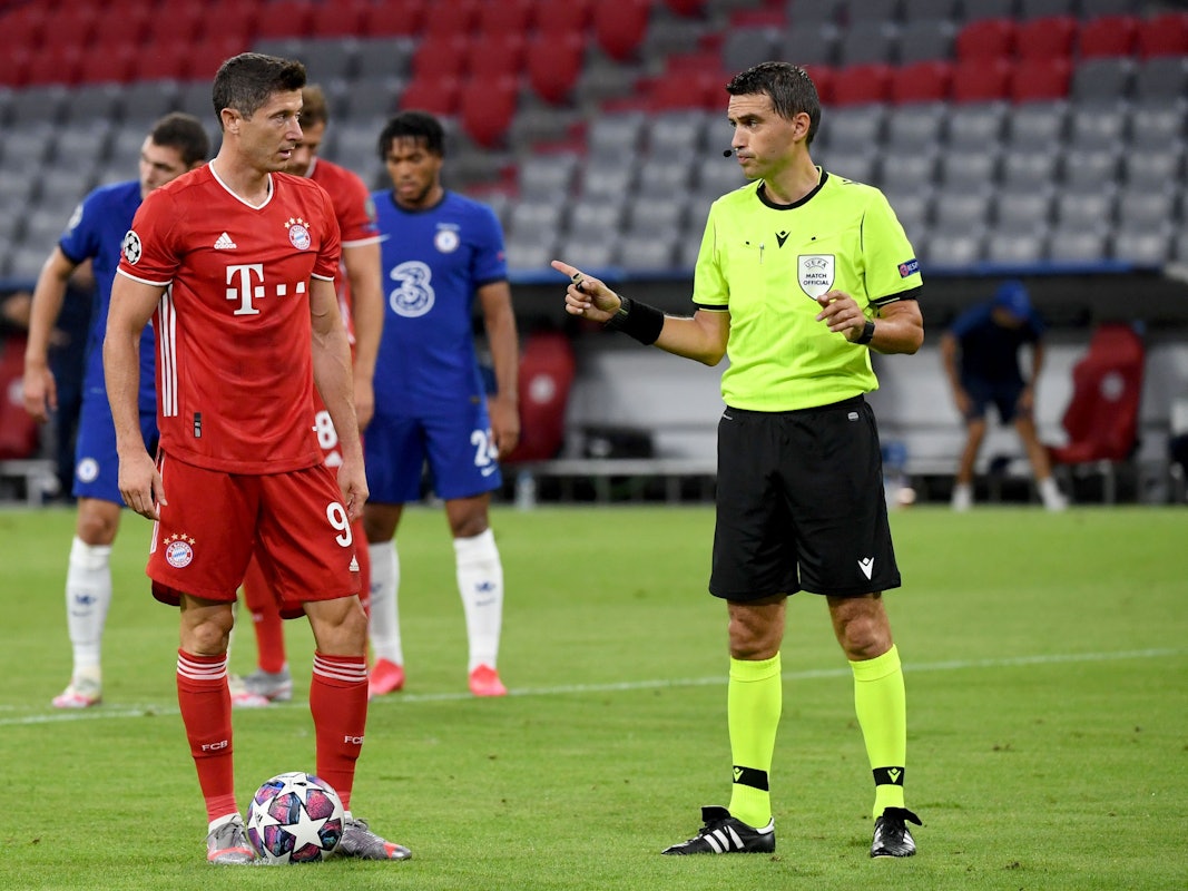 Bayern Münchens Robert Lewandowski steht neben Schiedsrichter Ovidiu Hațegan aus Rumänien vor seinem Elfmeter.