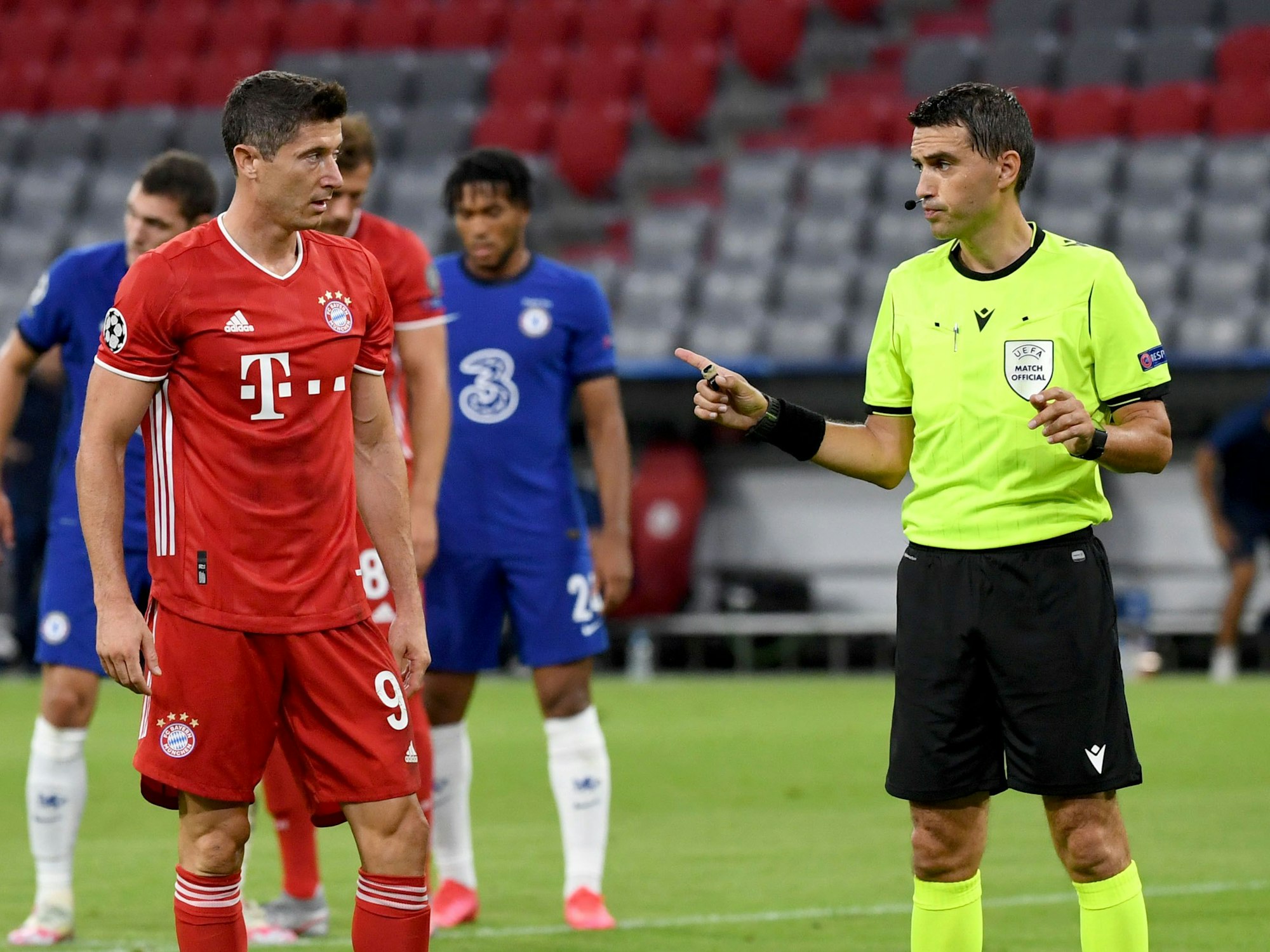 Bayern Münchens Robert Lewandowski steht neben Schiedsrichter Ovidiu Hațegan aus Rumänien vor seinem Elfmeter.