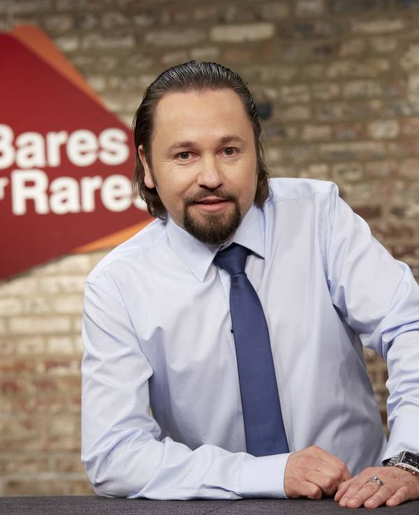 „Bares für Rares“-Händler Wolfgang Pauritsch posiert in der Kulisse der Show für ein Pressefoto.