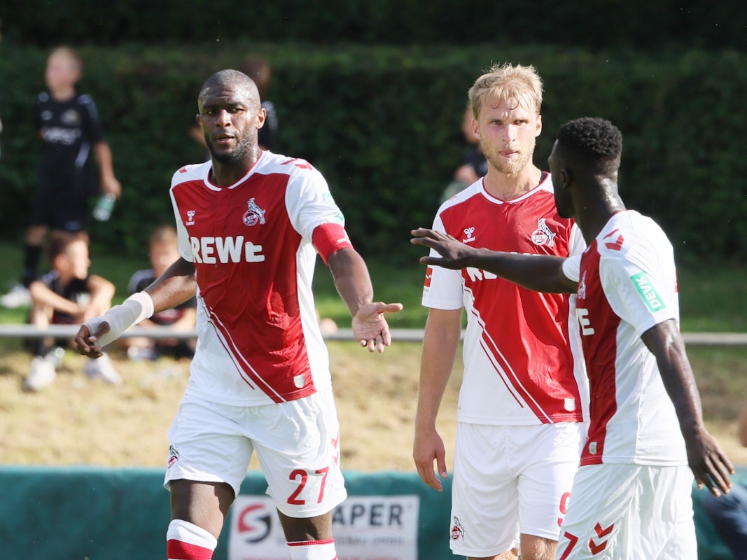 Die FC-Angreifer Anthony Modeste (l.) und Sebastian Andersson jubeln mit Kingsley Schindler (r.) beim Testspiel gegen den TuS Mondorf am 1. Juli 2022.