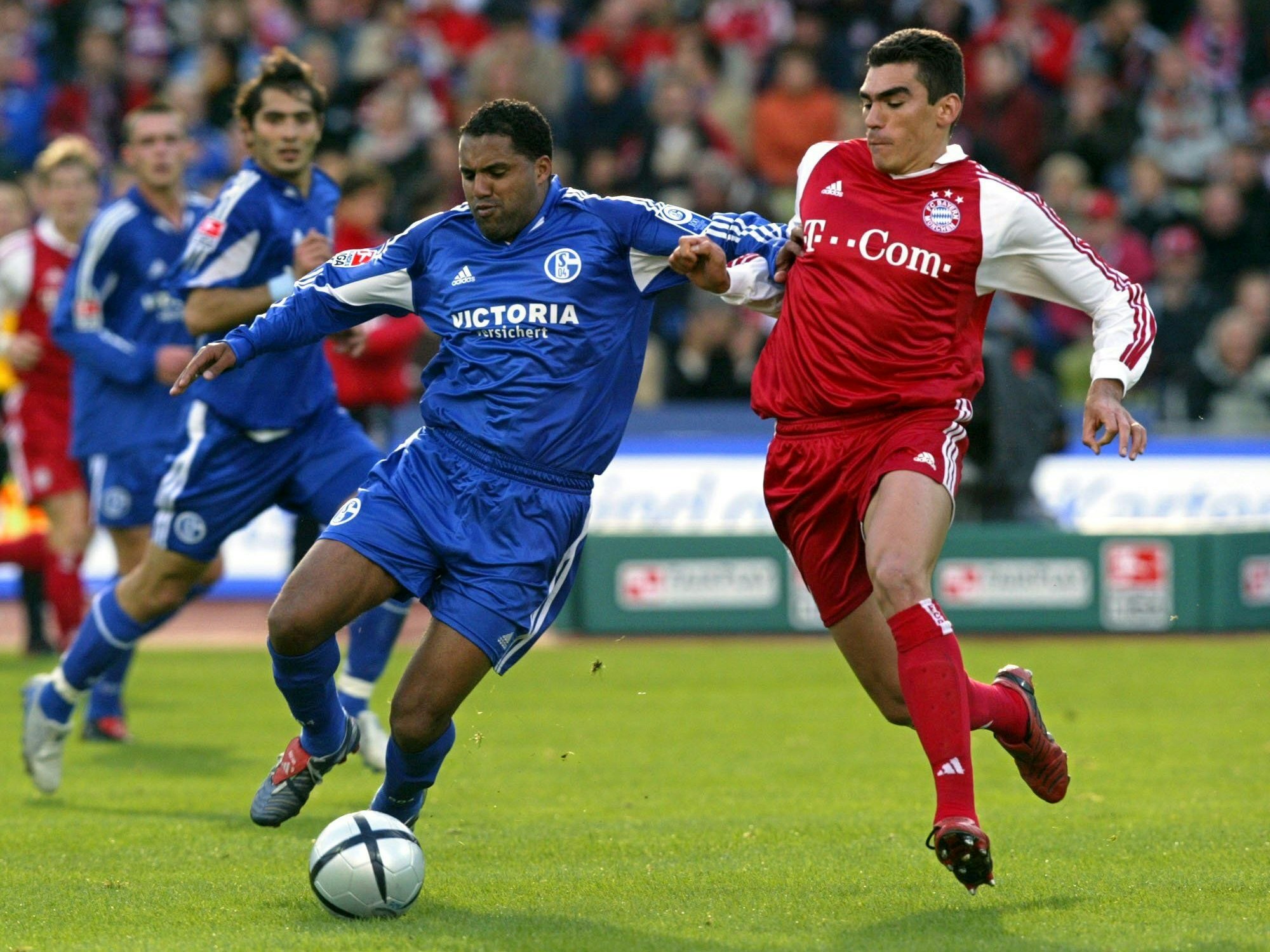 Schalkes Ailton und Bayerns Lucio versuchen, an den Ball zu kommen.