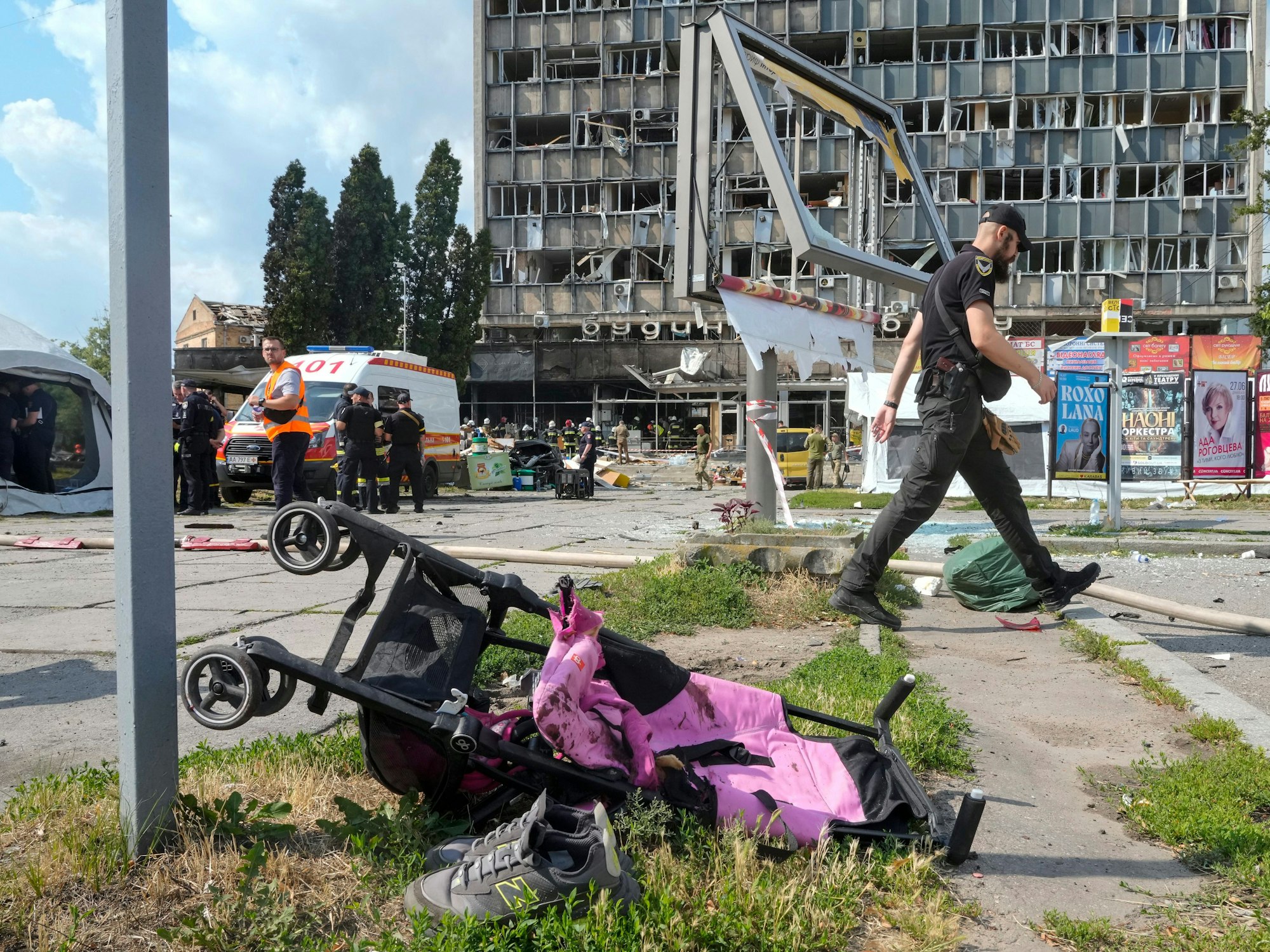 Ein mit Blut verschmierter Kinderwagen, im Hintergrund ein durch russische Bomben zerstörtes Haus. Hätte der ukrainische Präsident das wirklich verhindern können, fragt unsere Kollegin.