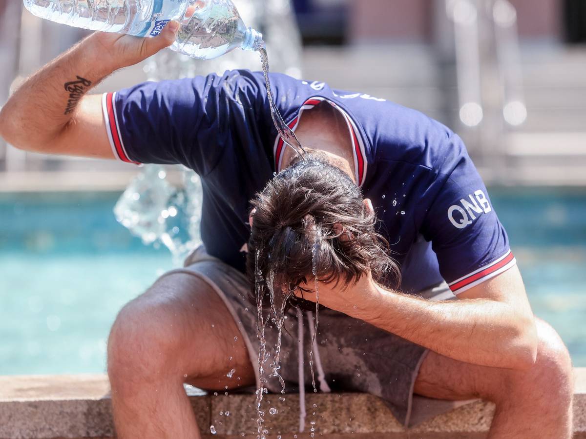 Ein junger Mann übergießt sich mit einer Wasserflasche, um die Hitze zu bekämpfen. Dieses Foto stammt aus Spanien.