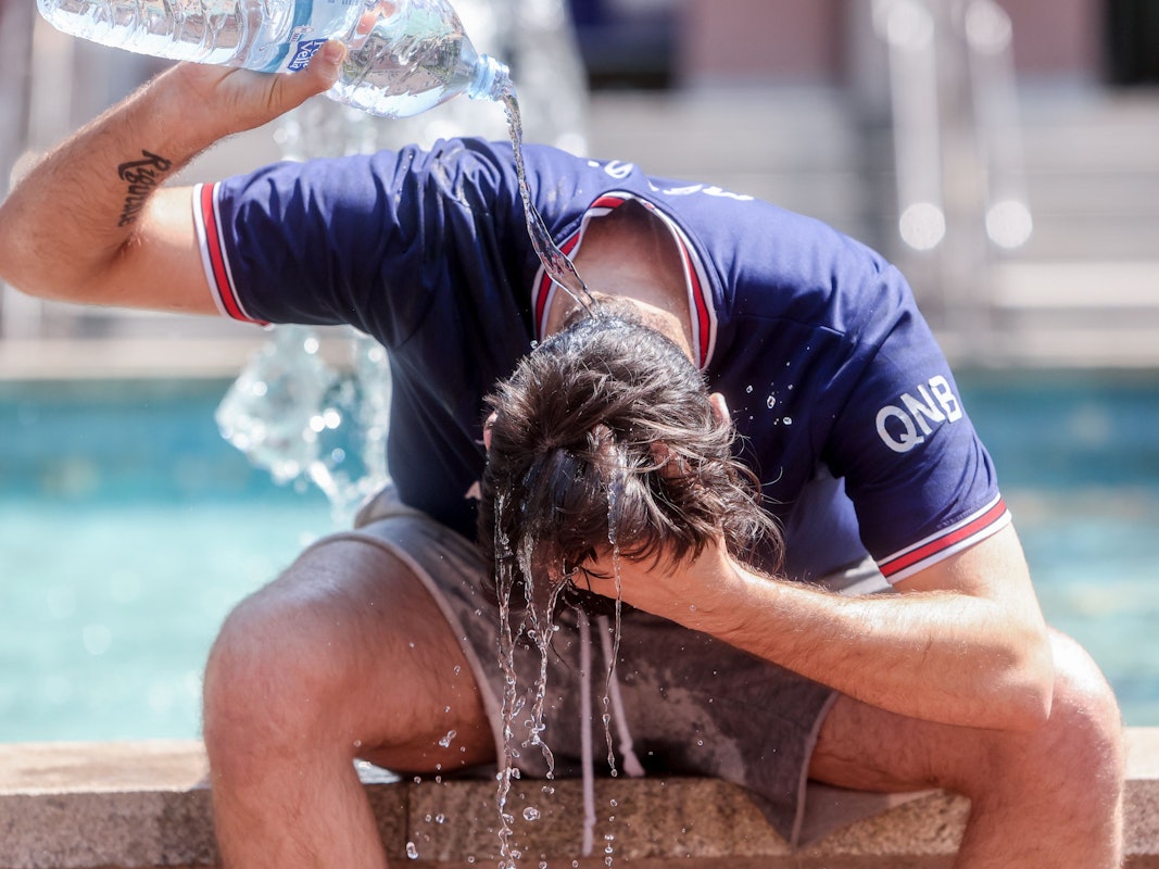 Ein junger Mann übergießt sich mit einer Wasserflasche, um die Hitze zu bekämpfen. Dieses Foto stammt aus Spanien.