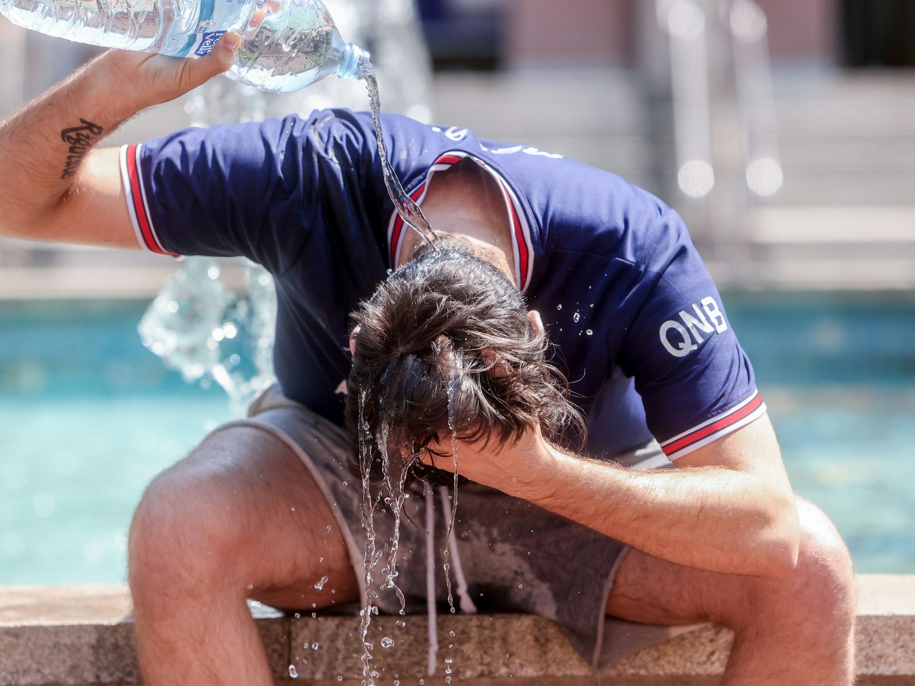 Die Hitzewelle sorgt in Spanien für unerträgliche Temperaturen. Doch in Deutschland wird es wohl doch nicht so schlimm. Unser Foto zeigt einen Mann, der sich mit einer Wasserflasche Abkühlung verschafft.