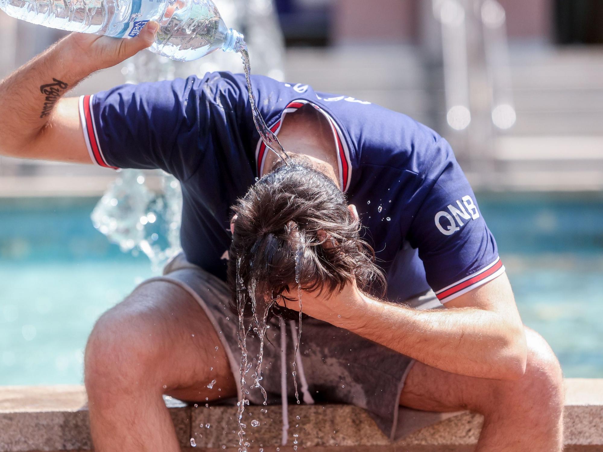 Die Hitzewelle sorgt in Spanien für unerträgliche Temperaturen. Doch in Deutschland wird es wohl doch nicht so schlimm. Unser Foto zeigt einen Mann, der sich mit einer Wasserflasche Abkühlung verschafft.