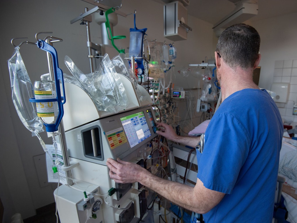 Ein Arzt bedient ein medizinisches Gerät auf einer Intensivstation.