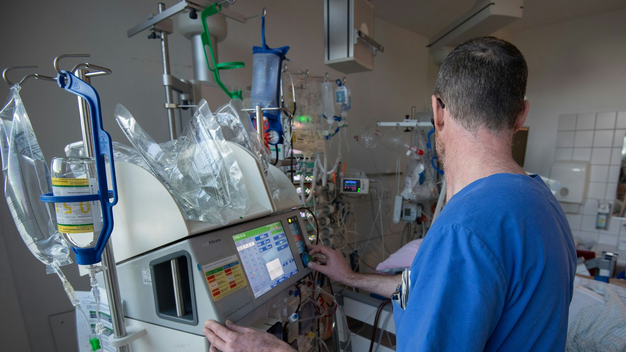 Ein Arzt bedient ein medizinisches Gerät auf einer Intensivstation.