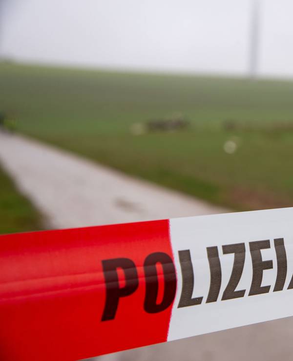 Ein Flatterband der Polizei mit dem Schriftzug «Polizeiabsperrung» sperrt eine Straße an einer Unfallstelle nach dem Absturz eines Kleinflugzeugs.