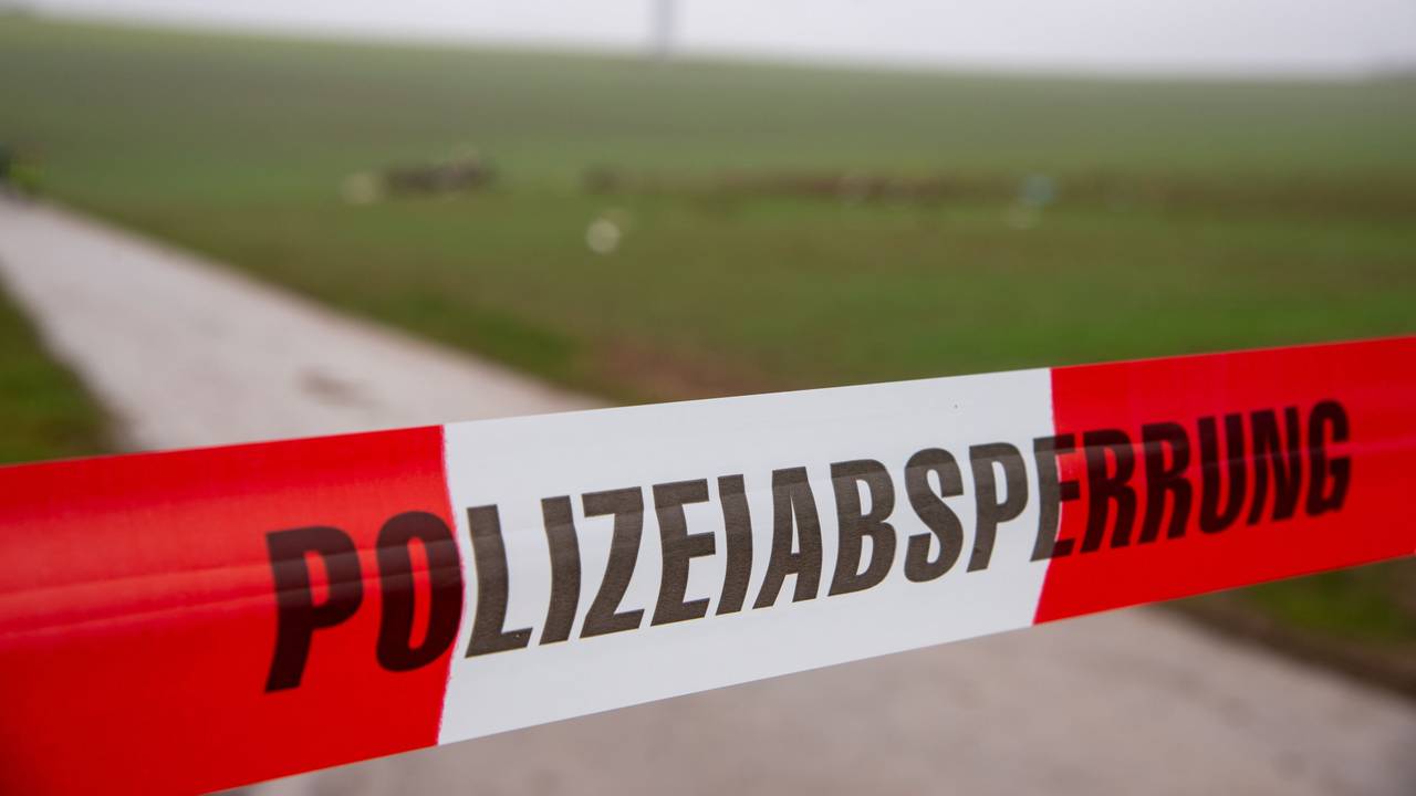 Ein Flatterband der Polizei mit dem Schriftzug «Polizeiabsperrung» sperrt eine Straße an einer Unfallstelle nach dem Absturz eines Kleinflugzeugs.