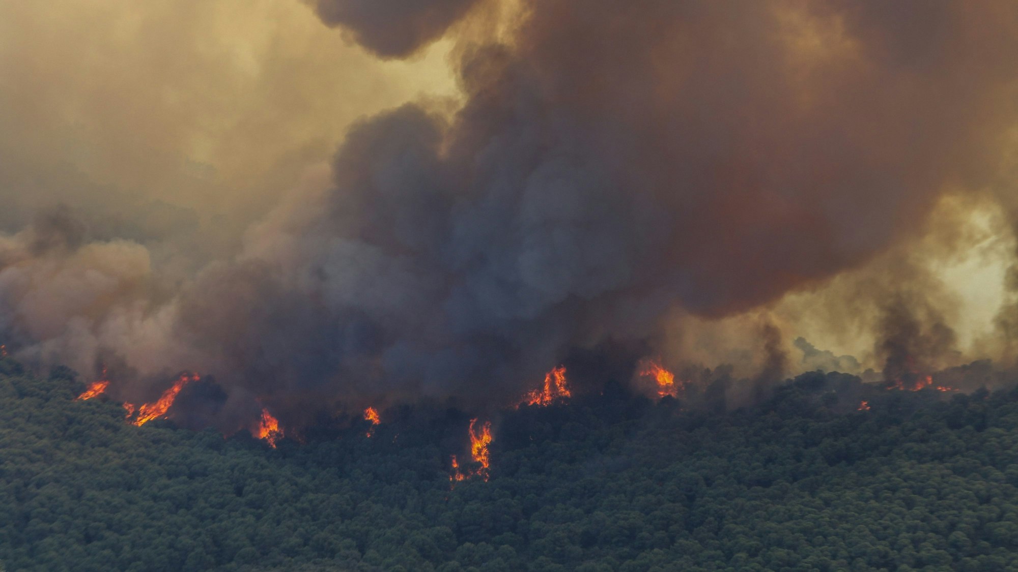 15.07.2022, Spanien, Alhaurin de la Torre: Der Brand in der Sierra de Mijas zwang zur Evakuierung von 2.300 Menschen in Alhaurín El Grande und Alhaurin de la Torre. Der Rauch dieses Waldbrandes kann von verschiedenen Teilen der Provinzhauptstadt Malaga aus gesehen werden, wie z.B. vom Pier One oder der Siedlung Guadalhorce. Man kann die Flammen von verschiedenen Punkten aus sehen. Vom gleichen Kommandoposten aus kann man den Berg mit riesigen Feuerzungen brennen sehen.