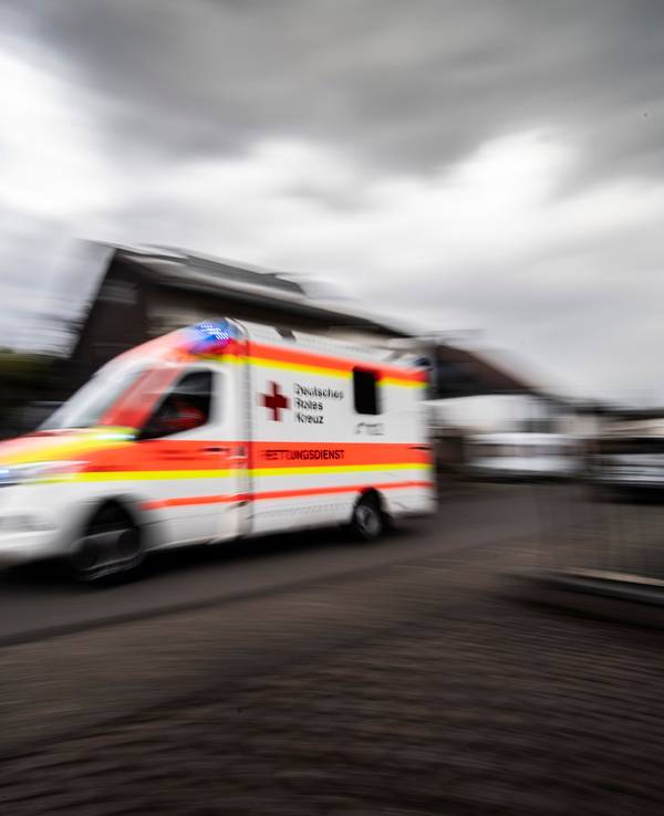 Rettungswagen fährt mit hoher Geschwindigkeit durch eine Straße.