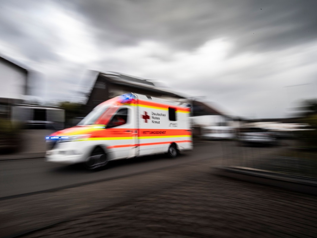 Rettungswagen fährt mit hoher Geschwindigkeit durch eine Straße.