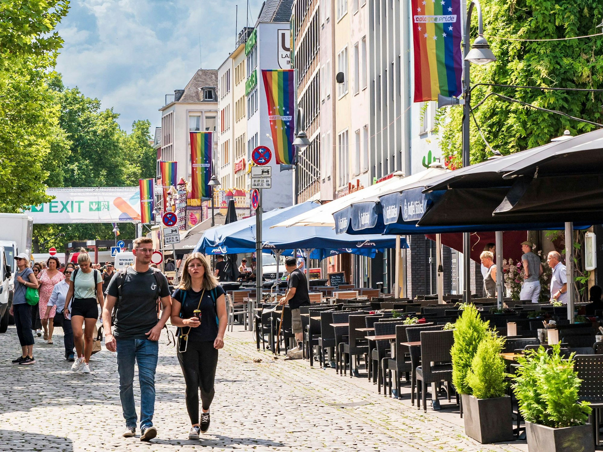 Menschen gehen durch die Kölner Altstadt kurz vor dem Christopher Street Day.