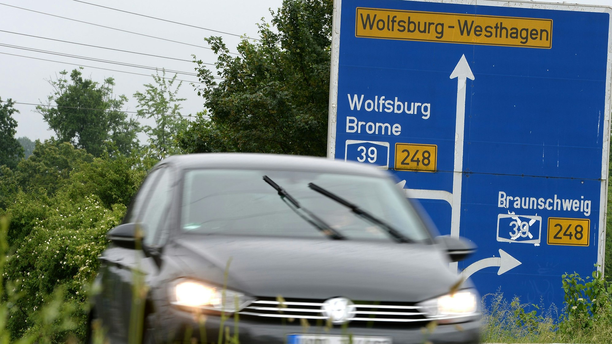 Ein Auto fährt vor einem Schild zur A39 entlang.