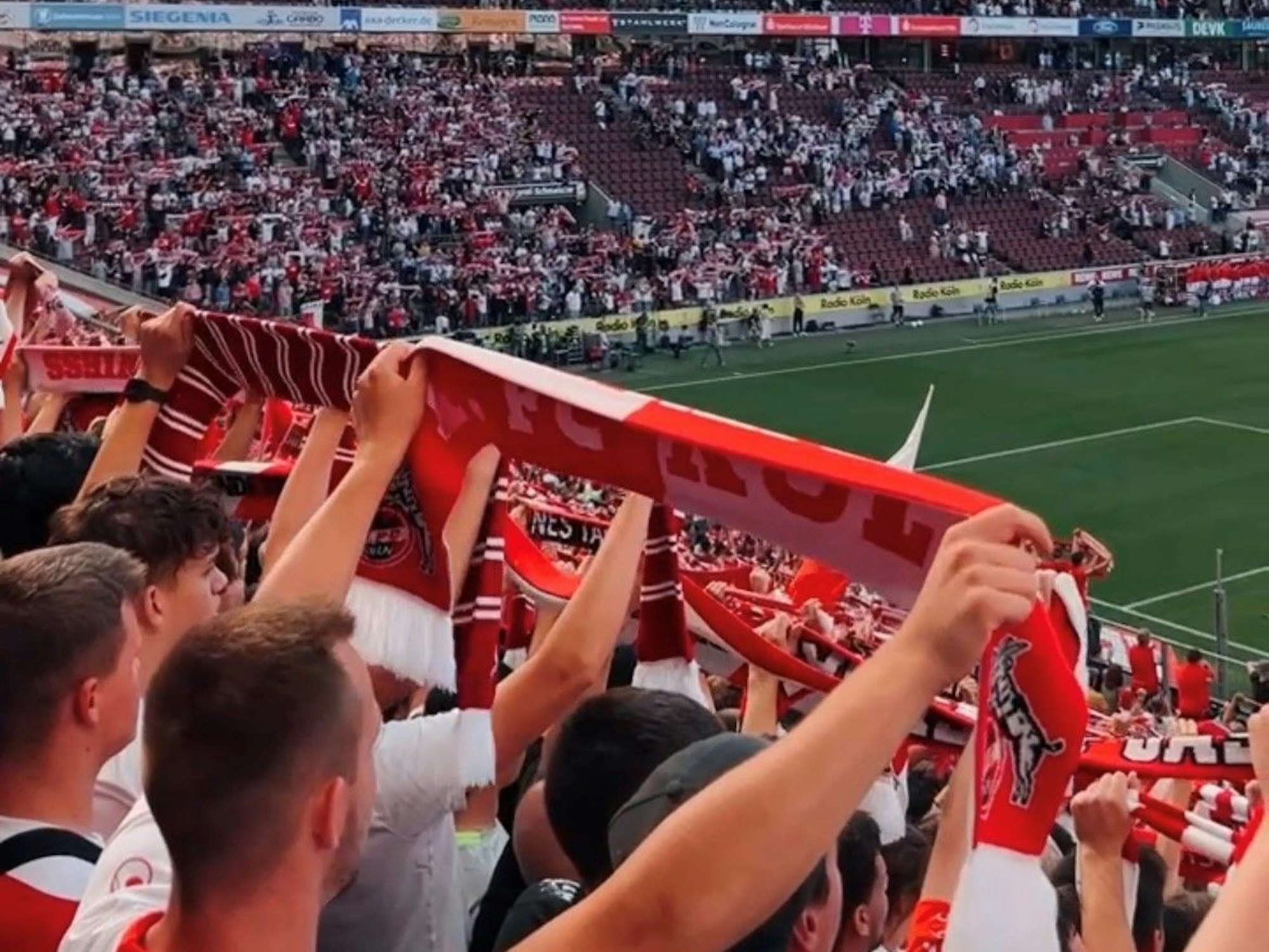 Fans des 1. FC Köln halten Ihre Schals auf der Südtribüne hoch.
