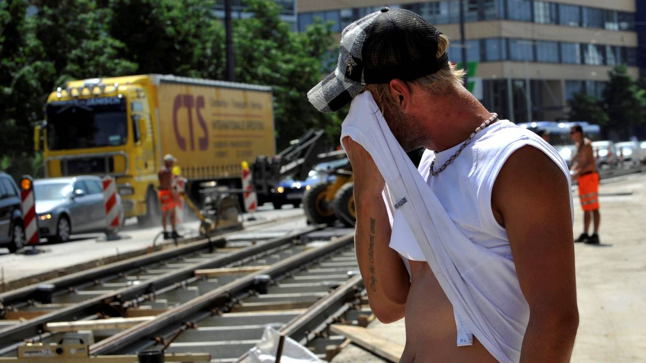 Ein Straßenarbeiter wischt sich am Montag (12.07.2010) in der Grillparzerstraße im Stadtteil Haidhausen in München (Oberbayern) bei großer Hitze den Schweiß ab.