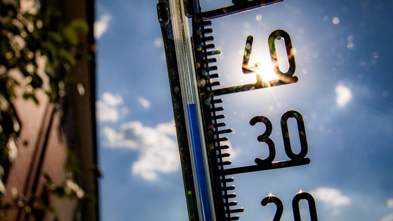 Ein Thermometer an einer Hauswand zeigt Temperaturen in Richtung der 40-Grad-Marke an.