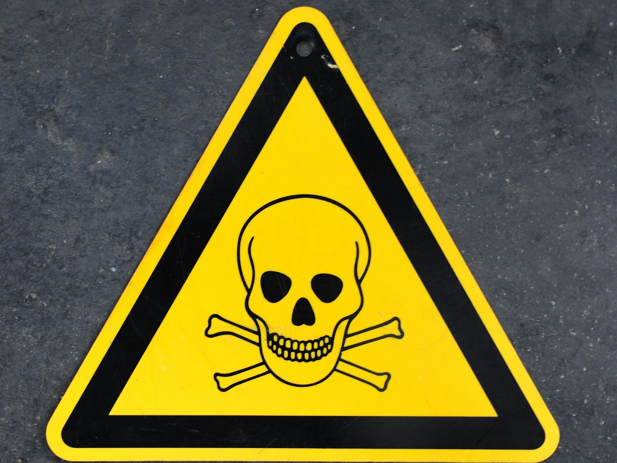 Eine Warntafel mit Totenkopf, die vor Gift warnt