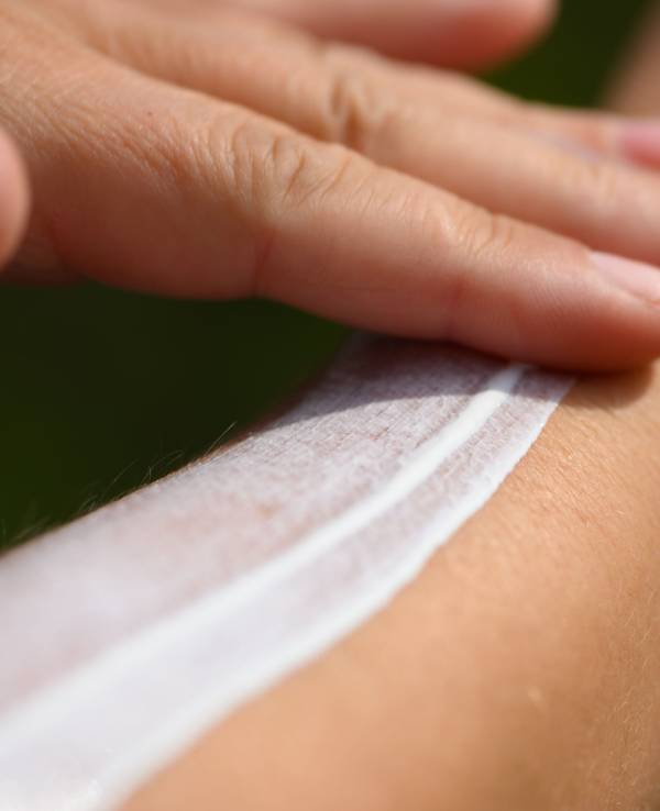 Eine Frau schmiert sich ihren Unterarm mit Sonnencreme ein.