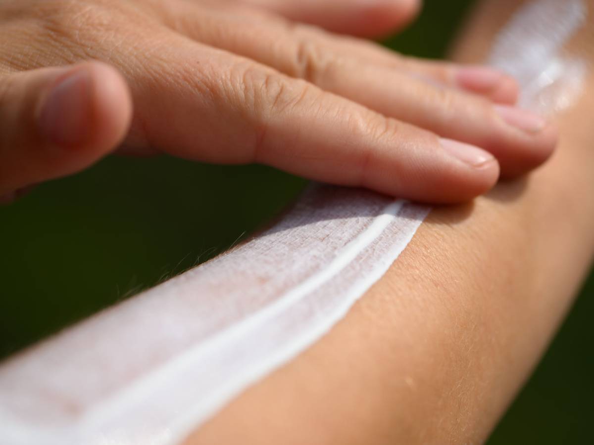 Eine Frau schmiert sich ihren Unterarm mit Sonnencreme ein.