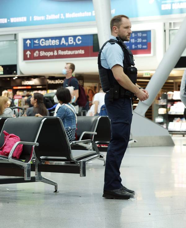 Zwei Kräfte der Bundespolizei stehen in einem Flughafengebäude.
