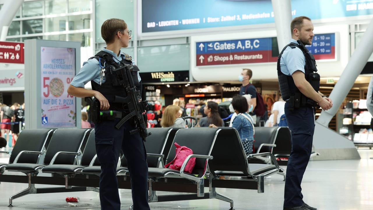 Zwei Kräfte der Bundespolizei stehen in einem Flughafengebäude.