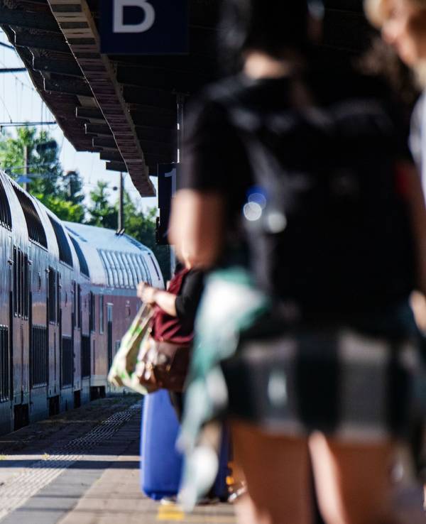 Fahrgäste warten im Bahnhof auf eine Regionalbahn.