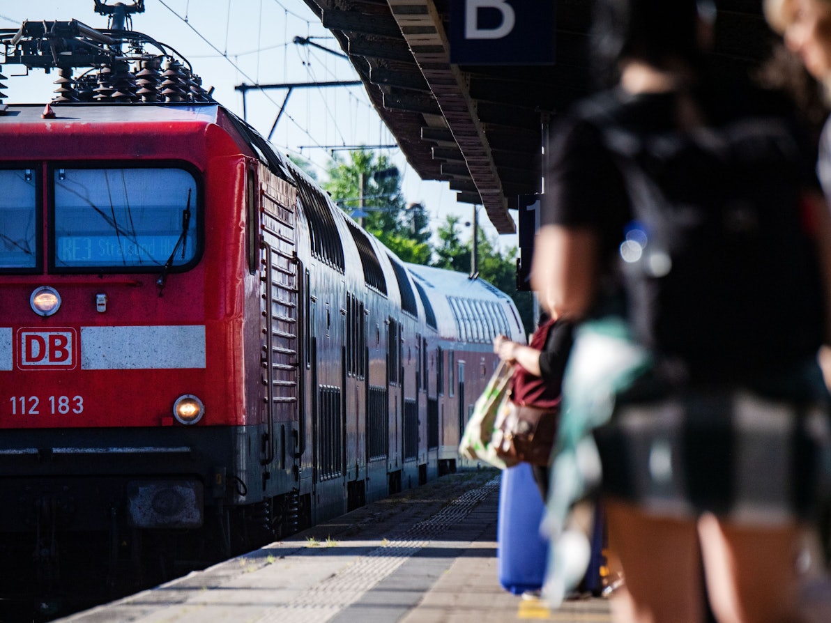 Fahrgäste warten im Bahnhof auf eine Regionalbahn.
