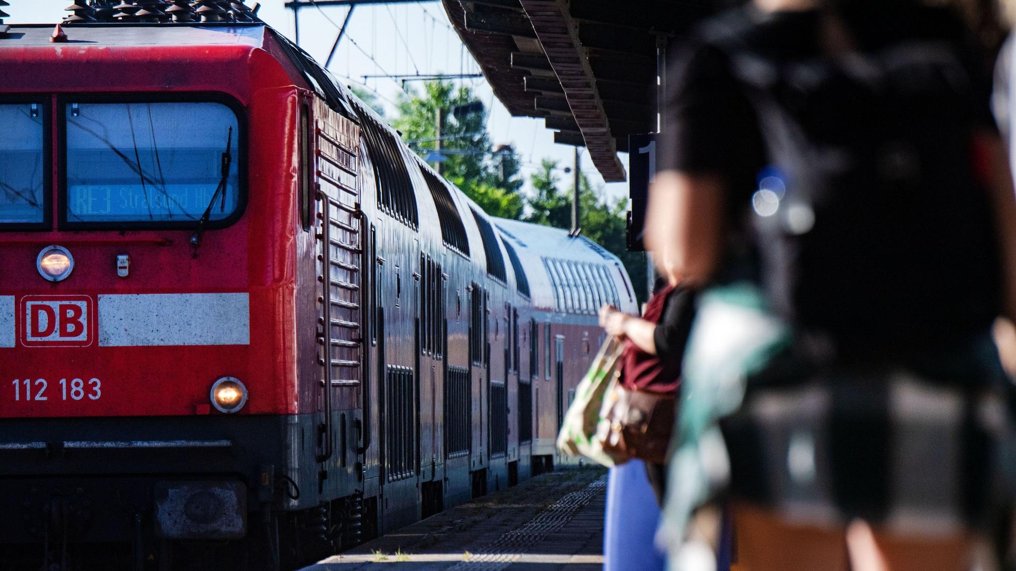 Fahrgäste warten im Bahnhof auf eine Regionalbahn.