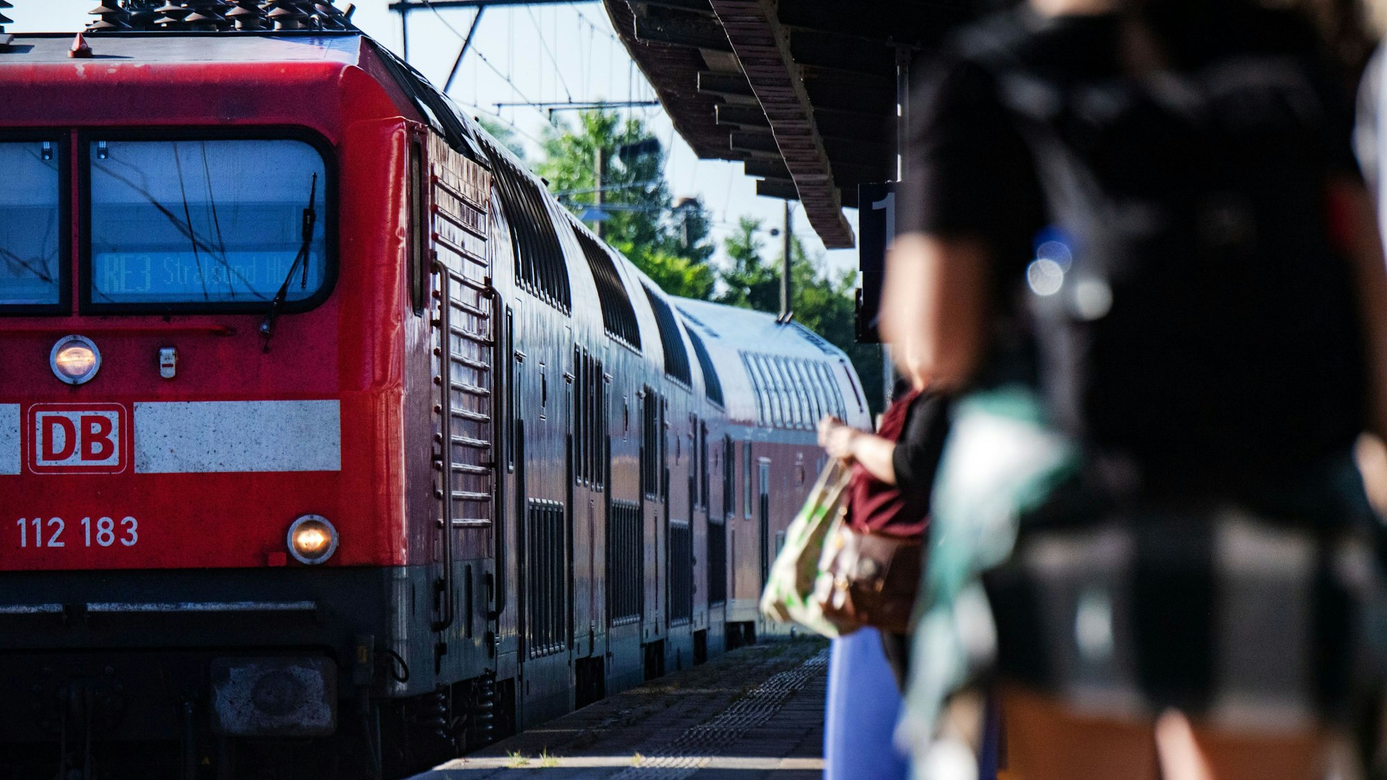 Fahrgäste warten im Bahnhof auf eine Regionalbahn.
