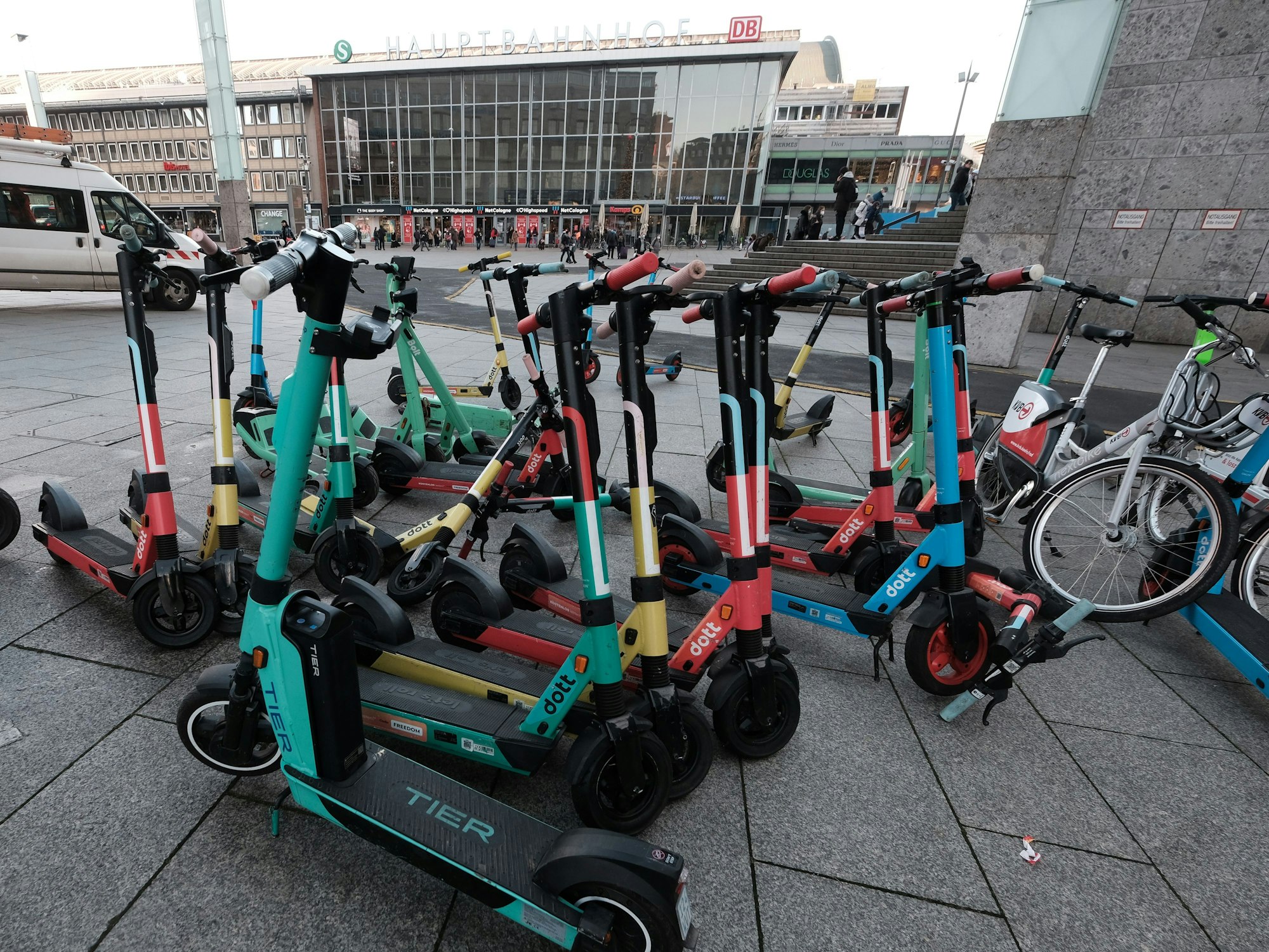 Mehrere Elektroroller stehen geparkt in Köln zusammen.