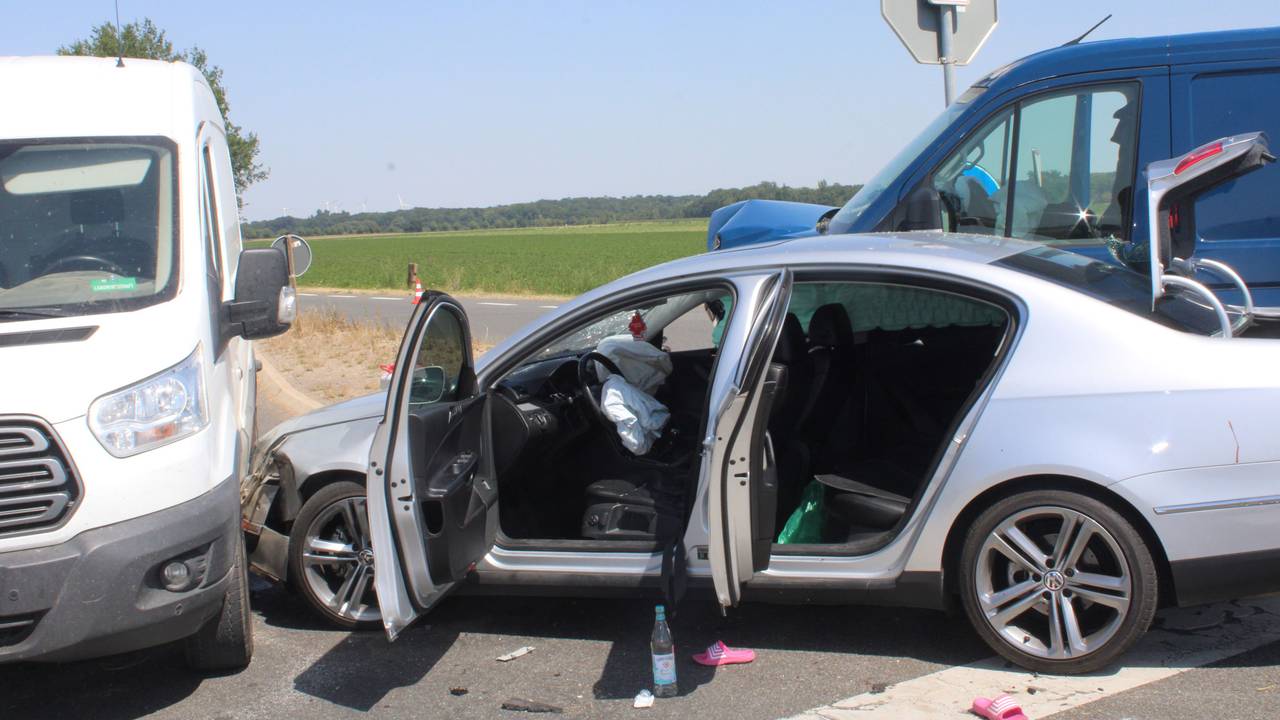 Ein Pkw ist mit einem Van zusammengestoßen, die Türen des Pkw stehen offen.