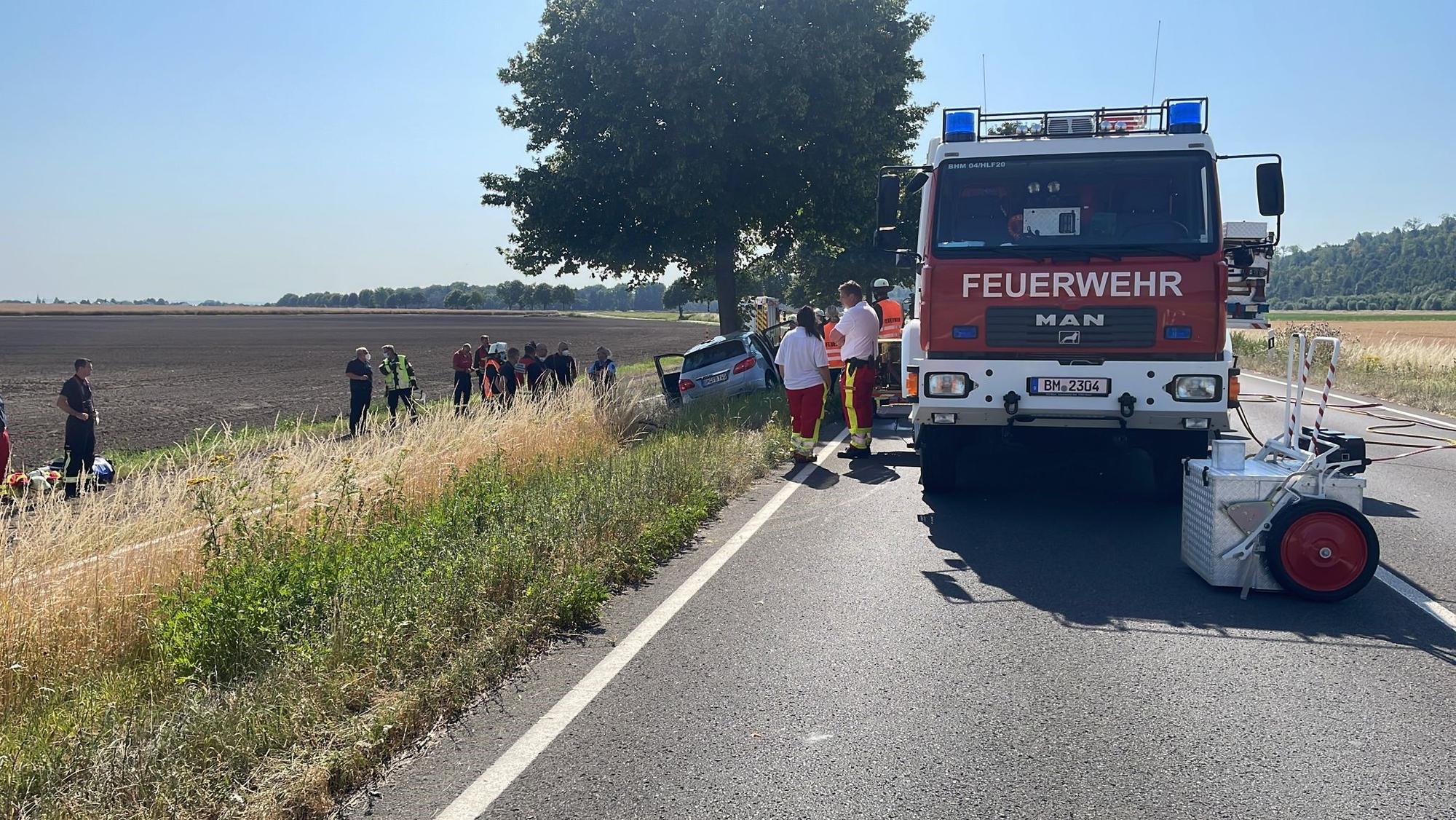 Feuerwehr und Notarzt bergen einen toten Mann, der mit seinem Mercedes gegen einen Baum prallte.