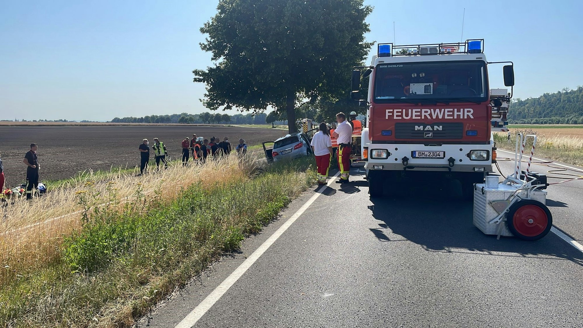 Feuerwehr und Notarzt bergen einen toten Mann, der mit seinem Mercedes gegen einen Baum prallte.