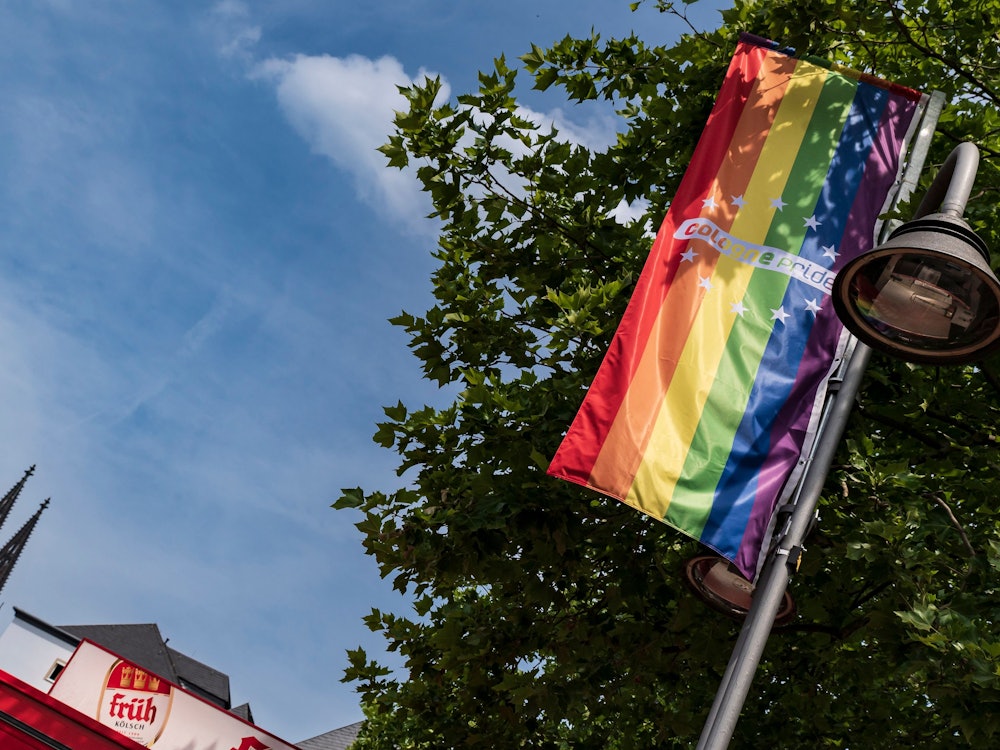 Eine Regenbogenflagge hängt an einem Fahnenmast in Köln.