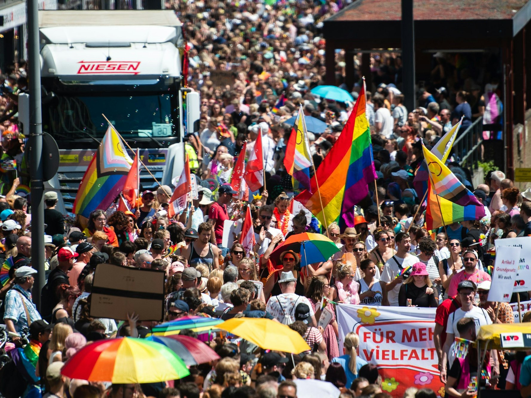 Teilnehmer und Teilnehmerinnen einer Parade zum Christopher Street Day (CSD) ziehen in Köln durch die Stadt.
